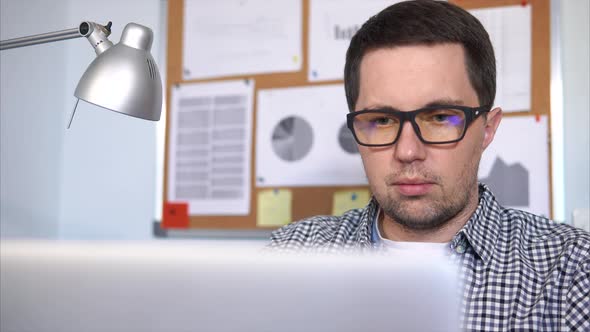 Businessman Sitting at Workplace and Working with His Laptop.