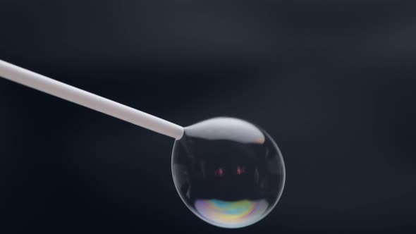 Beautiful soap bubbles are blown with a straw on a black background.Abstract soap bubbles with color