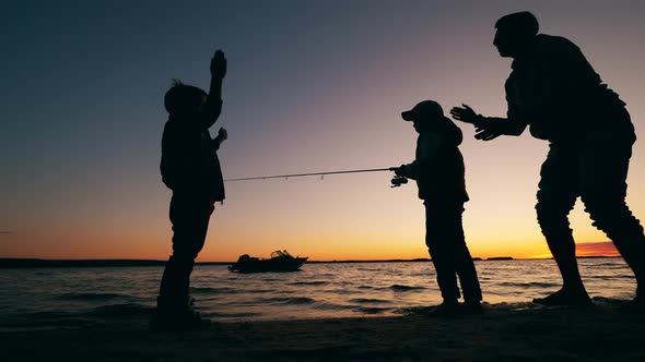 Kids and Their Dad Are Being Happy While Fishing at Sunset