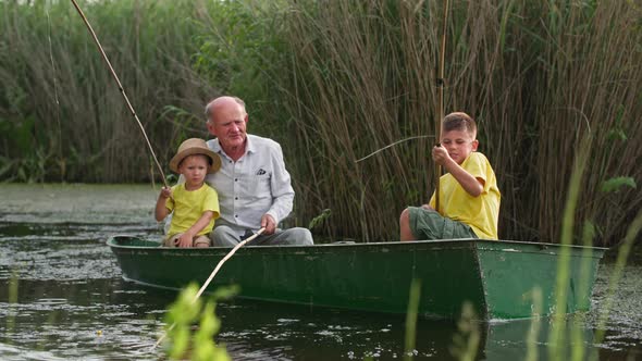 Kind Granddad Teaches His Grandchildren to Fish on River Family Having Fun Together in Boat Near