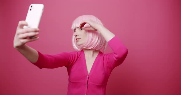 Young Nice Woman with Pink Hair Taking Photos Self on Isolated Pink Background