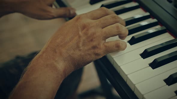 A Man Plays Music on a Keyboard Instrument