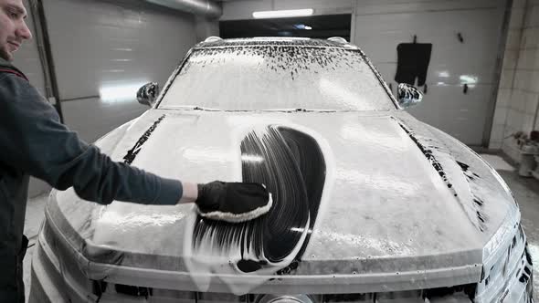 Man Washing the Car Bonnet After Shampooing the Bodywork Wiping the Car Surface with a Special