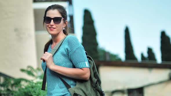 Portrait of Young Smiling Female Traveler in Sunglasses Medium Shot
