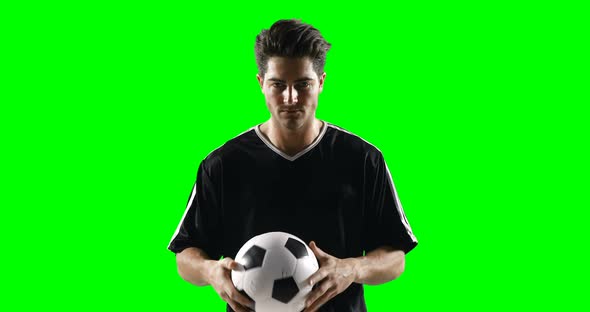 Football player holding a football against green screen