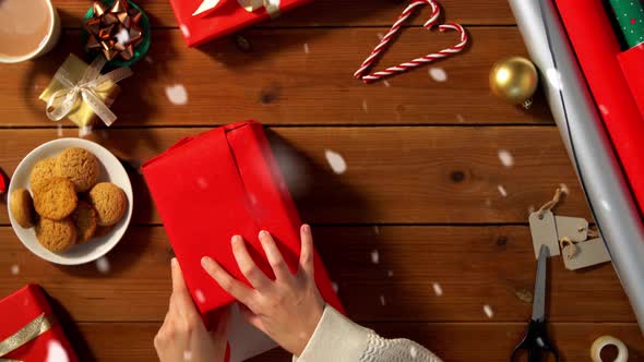 Woman Wrapping Christmas Gift Into Paper at Home