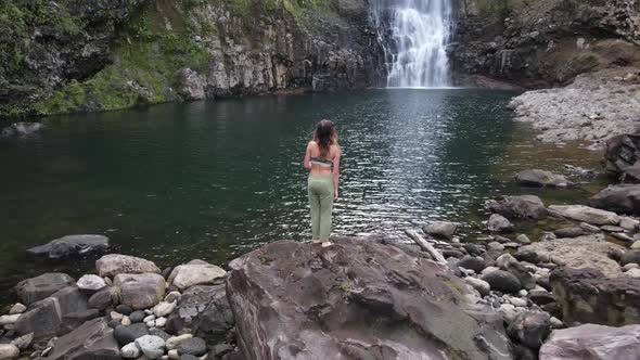 Aerial View of Beautiful Girl at the Waterfall on the Island of Hawaii