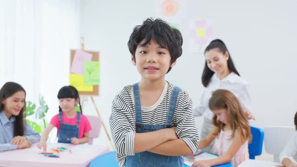 Portrait of Asian kid boy student stand with happiness in class room.