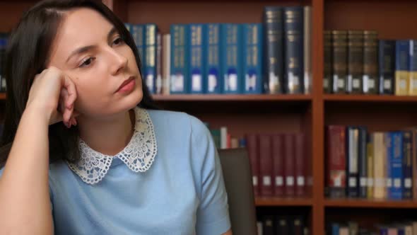 Portrait of Pretty Tired Business Woman Having Headache Sitting at Office Desk Bookshelf Background