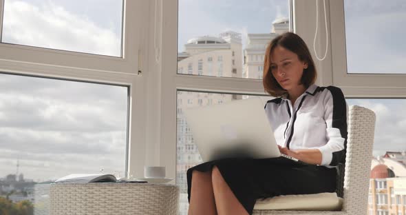 Businesswoman is working on laptop in white modern office