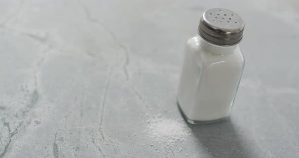 Video of salt in a salt shaker on stone kitchen worktop