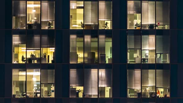 Window of the Multistorey Building of Glass and Steel Lighting and People Within Timelapse