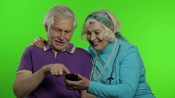 Mature Senior Old Couple Grandparents Enjoy Online Shopping on Mobile Phone