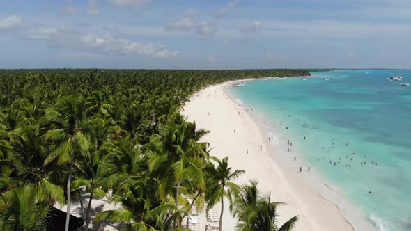 Lots of People on a Tropical Beach Hanging Out and Swimming in the Ocean