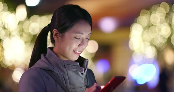 Woman use of mobile phone over golden light blur background