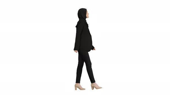 Smiling Islamic Female Model Wearing Hijab Walking and Looking Ahead on White Background.