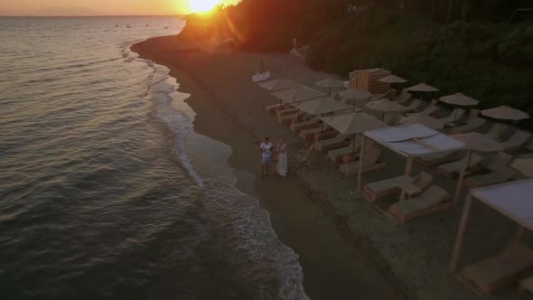 Family at the Beach and Aerial Scene of Coastal Town. Trikorfo Beach, Greece