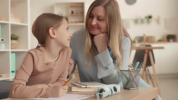 Schoolgirl Doing Test with Help of Her Mom