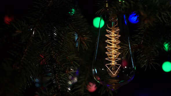 Light Bulb Turns on and Off on the Background with Garlands. Close Up