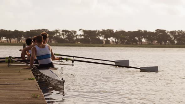 Male rower team getting ready to practice rowing on lake