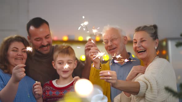 Cheerful Family with Different Ages Holding Sparkles Celebrating Christmas