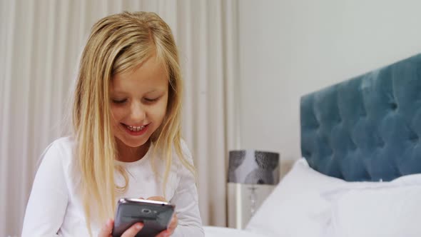 Happy girl using mobile phone on bed 4k