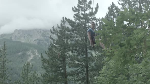 A man repels down a mountain while rock climbing.