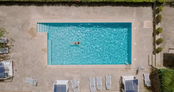 Aerial View of a Woman in Red Swimsuit Swimming in the Pool