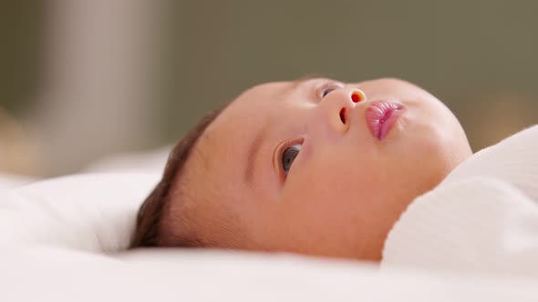 happy newborn baby lying on a white bed and blanket comfortable and safety