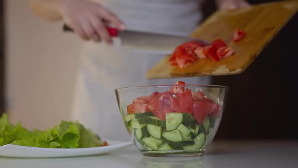 Female Chef Pours Cut Tomatoes Into Bowl Cooking Salad