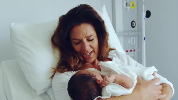 Front view of Caucasian mother holding her newborn baby in the ward at hospital