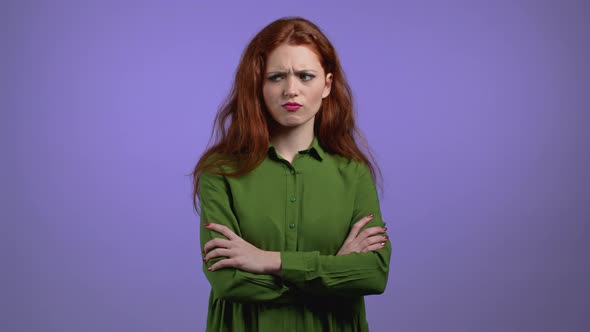 Offended Woman Keeping Arms Crossed Feeling Mad at Someone on Violet Studio Background