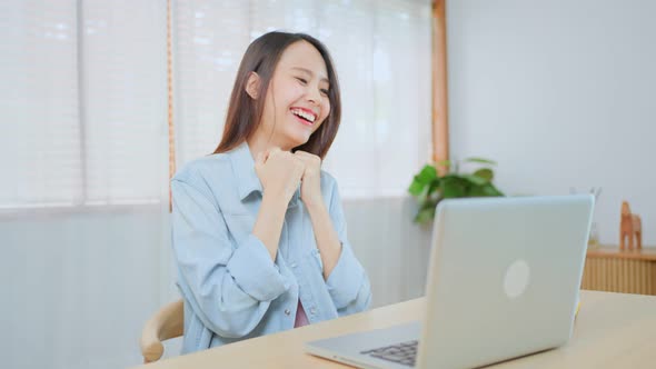 Asian excited young woman winner feel happy after looks at laptop and found out good news.