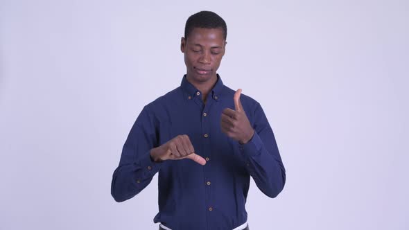 Young Confused African Businessman Choosing Between Thumbs Up and Thumbs Down