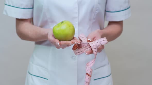 Nutritionist Doctor Healthy Lifestyle Concept - Holding Organic Green Apple and Measuring Tape