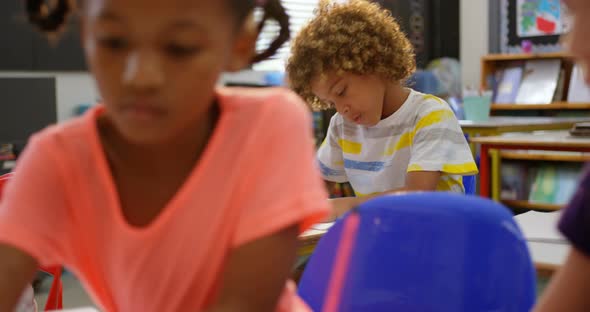 Front view of African American schoolboy studying in the classroom 4k