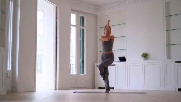 Flexible woman practicing yoga at home