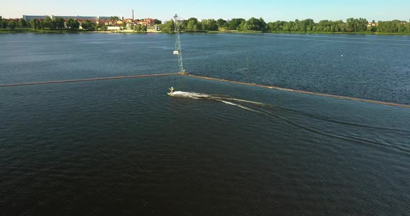 Aerial View of the Anchorage of the Cable Car Wake Park and an Athlete Cutting Through the Water on