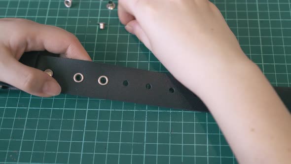 Skilled Tailor Puts Silver Eyelets Into Leather Belt Holes