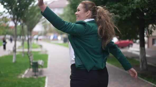 Tracking Shot Cheerful Plussize Caucasian Woman Walking on City Street Waving Greeting People