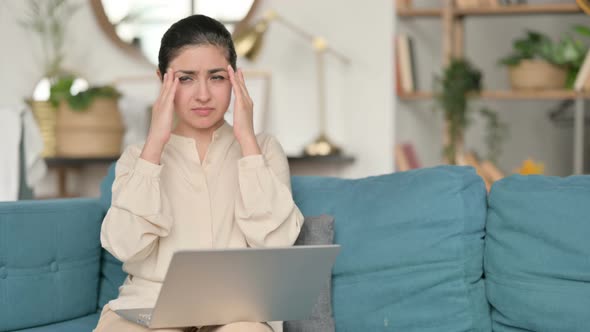 Indian Woman with Laptop Having Headache on Sofa 
