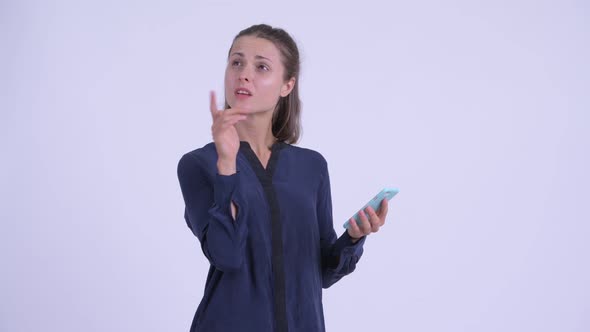 Happy Young Beautiful Businesswoman Thinking While Using Phone