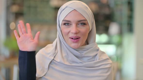 Portrait of Welcoming Young Arab Woman Waving Hello