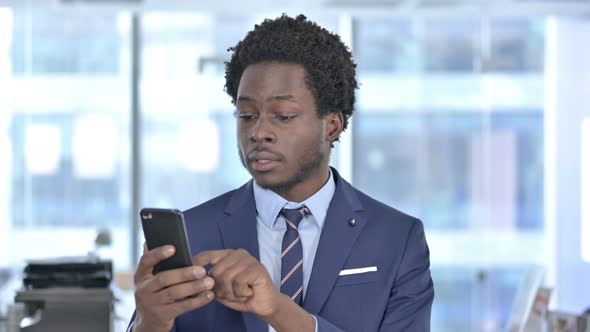 Ambitious African American Businessman Scrolling Cellphone