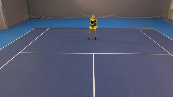 Extreme Wide Shot of Confident Beautiful Sportswoman Hitting Ball with Racket on Indoor Tennis Court