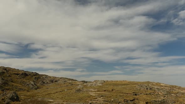 Time lapse of clouds moving over rugged landscape