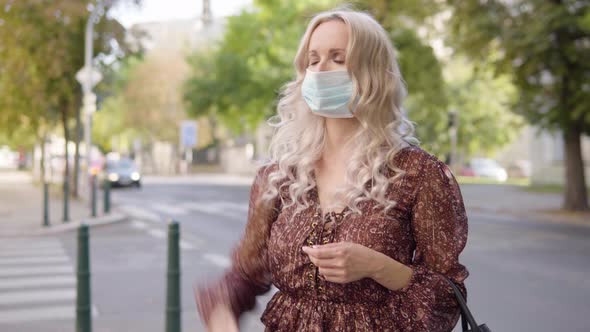 A Middleaged Caucasian Woman in a Face Mask Acts Frustrated in an Urban Area