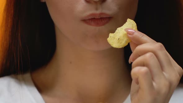 Young Lady Eating Spicy Potato Chips, Unhealthy Snack and Fast Food, Close Up
