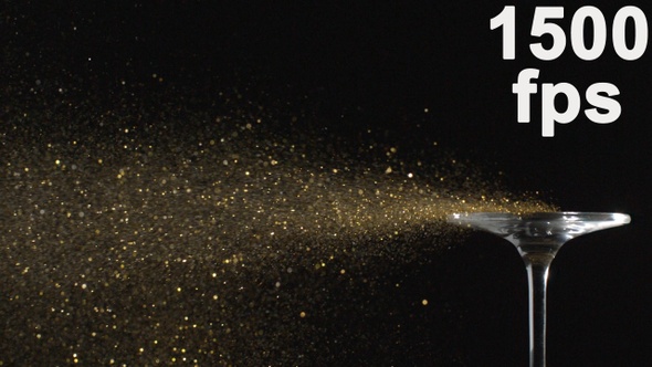 Golden Glitter Flying In The Air Is Blown Away From A Glass In Slow Motion On Black Background alt