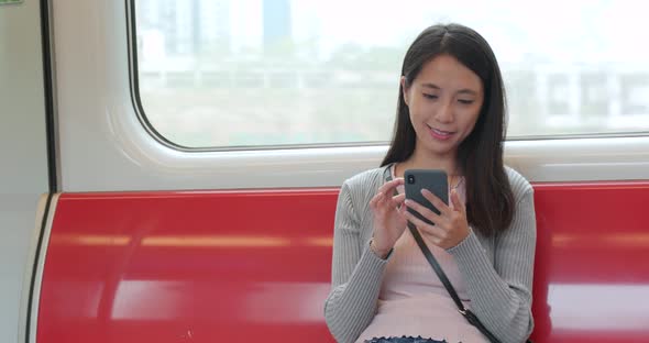 Woman using smart phone on train compartment